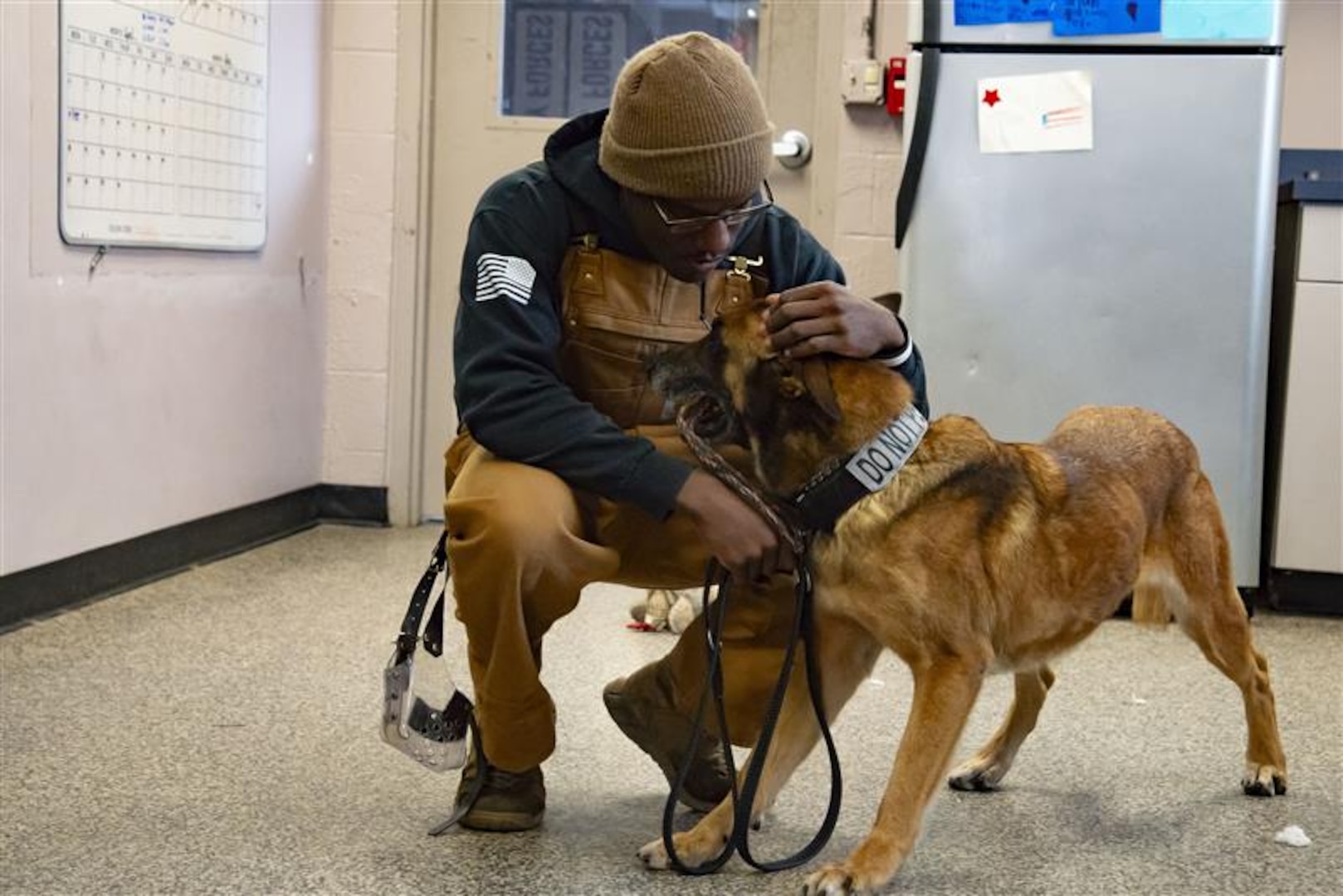 Senior Airman Jordon Johnson pets MWD Bulit.