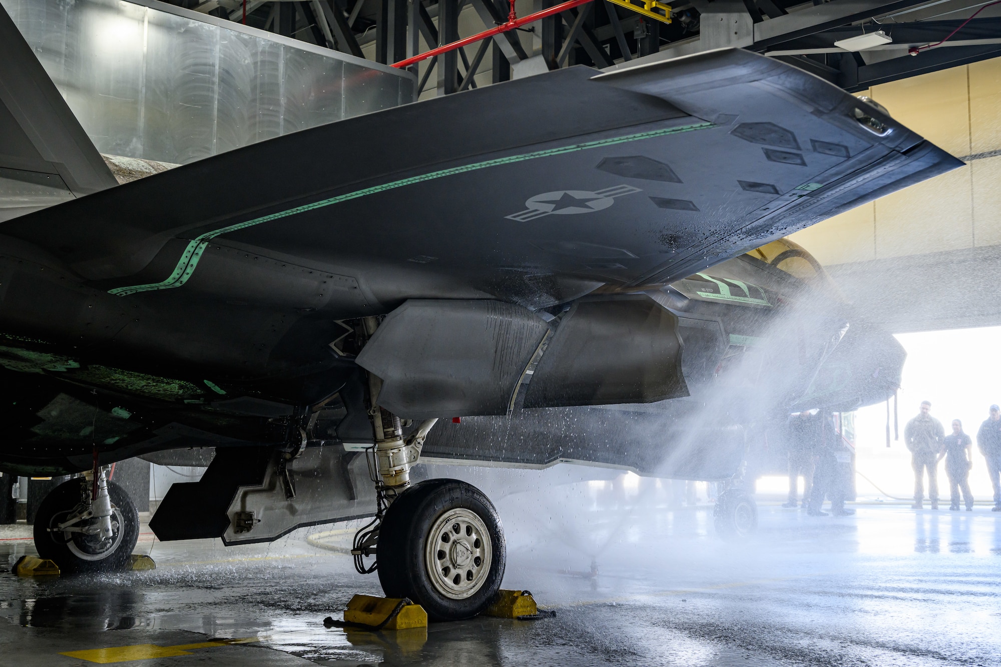 A photograph of firefighters training to extinguish battery fires on an F-35