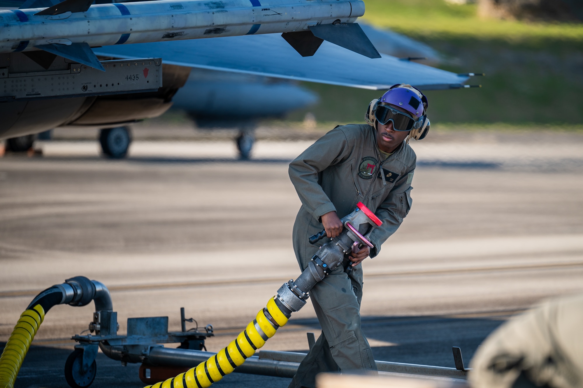 U.S. Marine Corps Cpl. Malachi Irving, Headquarters and Headquarters Squadron expeditionary fuel technician, conducts hot pit refueling on a U.S. Air Force F-16C Fighting Falcon assigned to the 120th Expeditionary Fighter Squadron, deployed to Kadena Air Base, during a USAF-led operational exercise Beverly Midnight 26 at Marine Corps Air Station Futenma, Japan, March 11, 2026. During BM26 PACAF forces exercised and trained at various locations, demonstrating the collective ability to deploy airpower throughout the Pacific. (U.S. Air Force photo by Airman 1st Class Francisco Huerta)