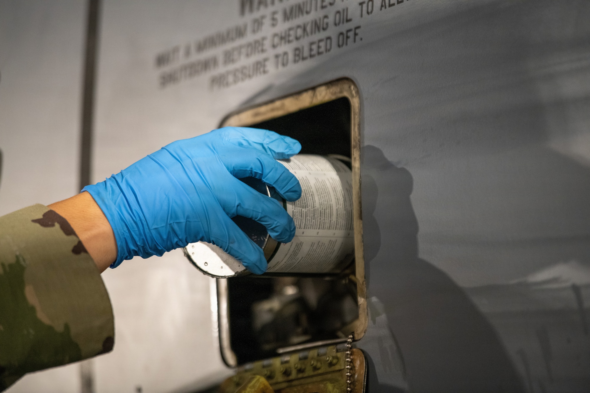 An Airman adds oil to an aircraft.