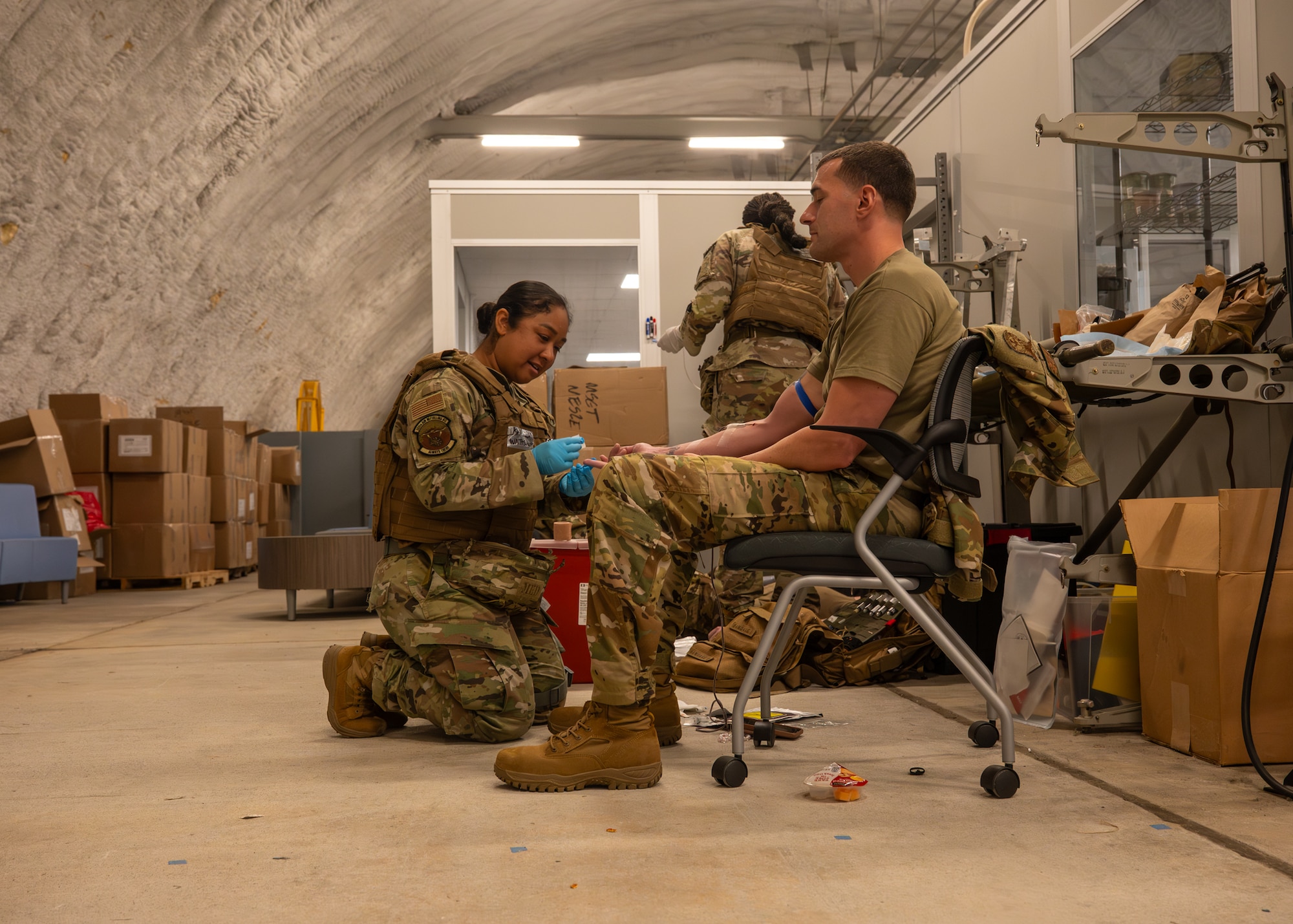 A military medic pricks a service member's fingers.