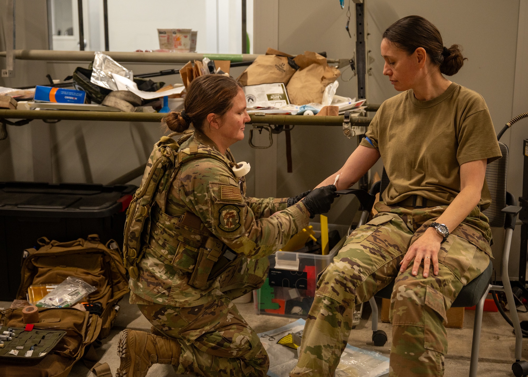 A medic inserts an IV into a service member's arm.