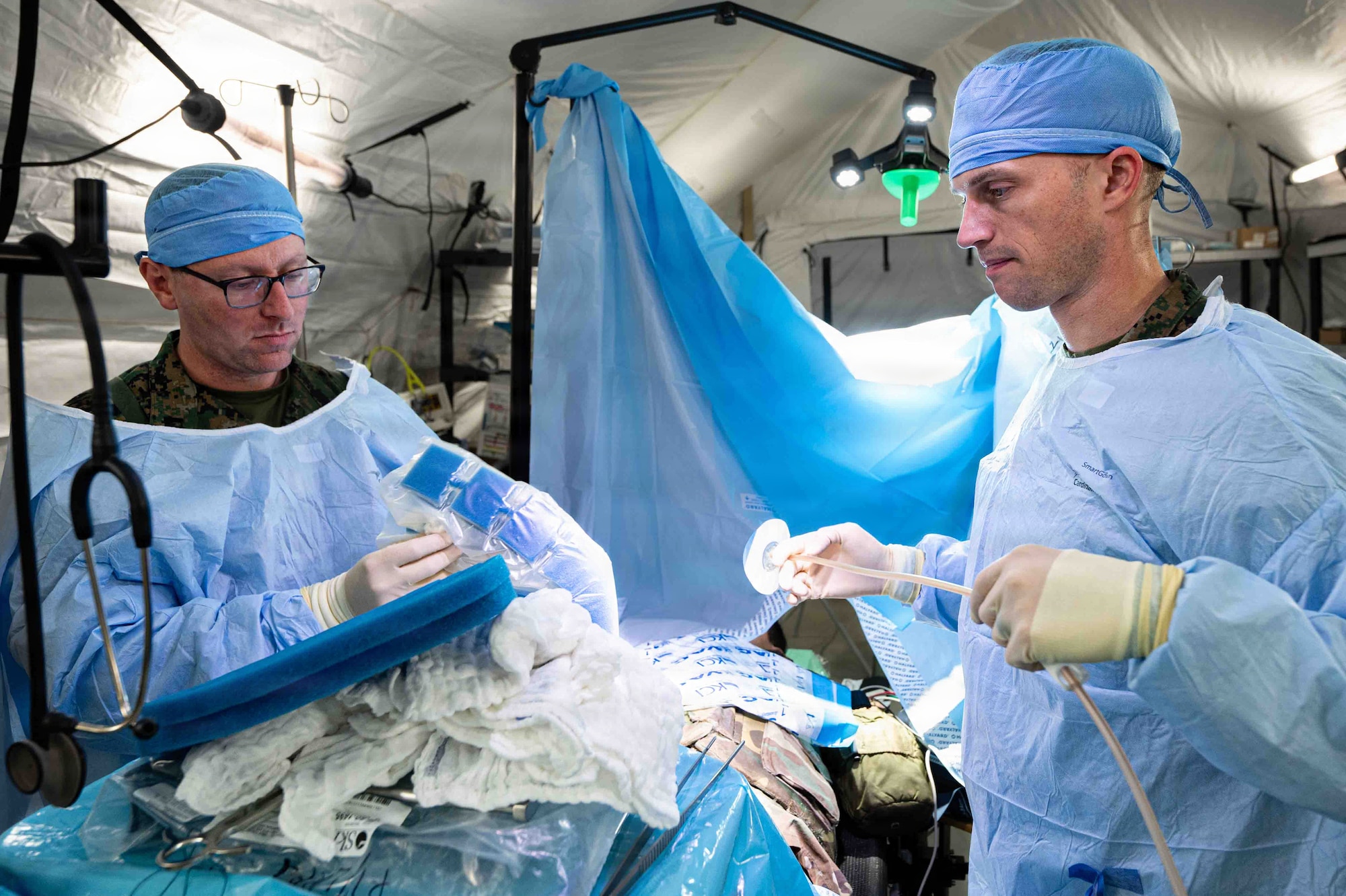 Service members simulate treating an abdominal injury.