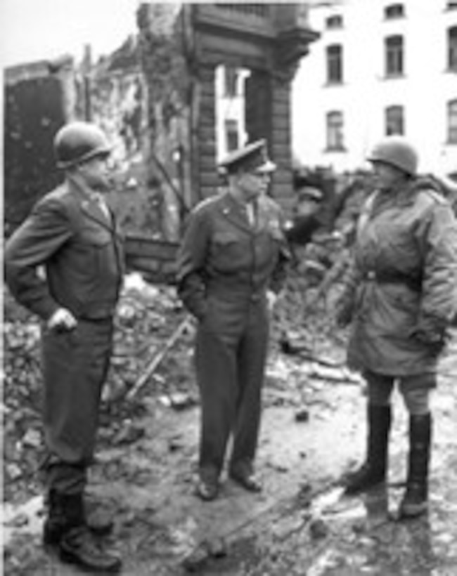 Three officers stand in the rubble of a building