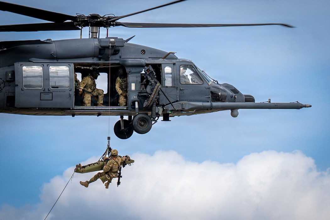 Airmen hanging form a HH-60