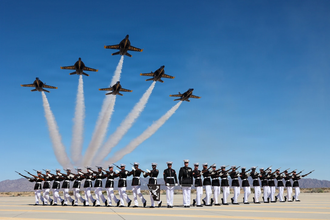U.S. Marines with the United States Marine Corps Silent Drill Platoon rehearse their silent drill sequence as U.S. Navy Blue Angels fly overhead at Marine Corps Air Station Yuma, Ariz., March 4, 2026. Together, the Silent Drill Platoon and the Blue Angels demonstrate the precision and discipline that have defined the naval services for generations. This preparation supports the Silent Drill Platoon’s role in the 2026 parade season, honoring America’s 250th anniversary through disciplined ceremonial excellence at Marine Barracks Washington. (U.S. Marine Corps photo by Cpl. Brynn L. Bouchard)
