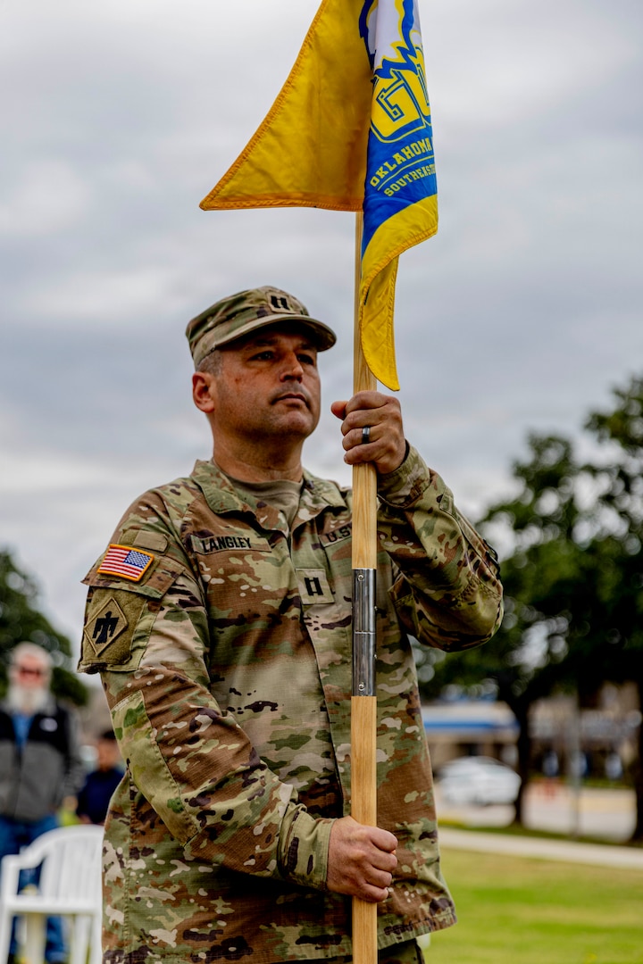 Oklahoma Army National Guard Capt. Eric Langley, commander of the Southeastern Oklahoma State University Guard Officer Leadership Development (GOLD) program, stands with the newly uncased guidon at a flagging ceremony for the SEOSU’s GOLD program held Wednesday, March 11, 2026 in Durant, Oklahoma. The OKARNG’s GOLD program is designed to develop and prepare individuals for commissioned officer roles, equipping them with the skills needed to lead Soldiers effectively. Upon completion, candidates will attend Officer Candidate School. Once a candidate has completed the GOLD and OCS programs, they will become commissioned officers. (Oklahoma National Guard photo by Sgt. Haden Tolbert)