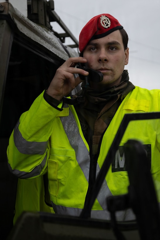 A Norwegian soldier talks on a radio in preparation for a convoy in Narvik, Norway, March 5, 2026. Norwegian forces and U.S. Marines partnered to direct traffic and provide security in support of exercise Cold Response 26. A key component of NATO's enhanced vigilance activity Arctic Sentry, exercise Cold Response 26 is a Norwegian-led winter military exercise designed to enhance collective defense capabilities and ensure U.S. readiness to rapidly deploy and seamlessly operate alongside NATO Allies in challenging arctic conditions. (U.S. Marine Corps photo by Sgt. Emily De La Torre)