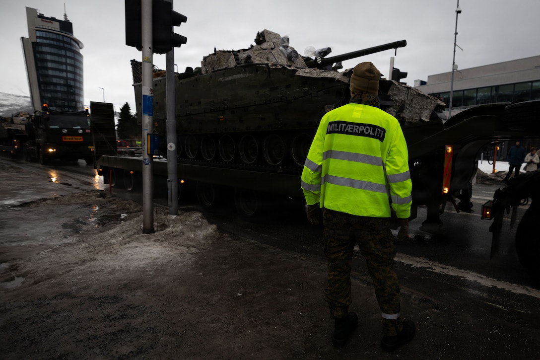 U.S. Marine Corps Cpl. Trevor Boesel, a military policeman with 4th Law Enforcement Battalion, Force Headquarters Group, Marine Forces Reserve, directs traffic for a convoy in Narvik, Norway, March 5, 2026. Norwegian soldiers and U.S. Marines partnered to direct traffic and provide security in support of exercise Cold Response 26. A key component of NATO's enhanced vigilance activity Arctic Sentry, exercise Cold Response 26 is a Norwegian-led winter military exercise designed to enhance collective defense capabilities and ensure U.S. readiness to rapidly deploy and seamlessly operate alongside NATO Allies in challenging arctic conditions. Boesel is a native of South Dakota. (U.S. Marine Corps photo by Sgt. Emily De La Torre)
