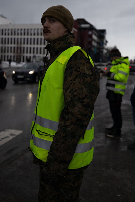 U.S. Marine Corps Cpl. Dillon Norman, a military policeman with 4th Law Enforcement Battalion, Force Headquarters Group, Marine Forces Reserve, prepares to direct traffic for a convoy in Narvik, Norway, March 5, 2026. Norwegian soldiers and U.S. Marines partnered to direct traffic and provide security in support of exercise Cold Response 26. A key component of NATO's enhanced vigilance activity Arctic Sentry, exercise Cold Response 26 is a Norwegian-led winter military exercise designed to enhance collective defense capabilities and ensure U.S. readiness to rapidly deploy and seamlessly operate alongside NATO Allies in challenging arctic conditions. Norman is a native of North Dakota. (U.S. Marine Corps photo by Sgt. Emily De La Torre)