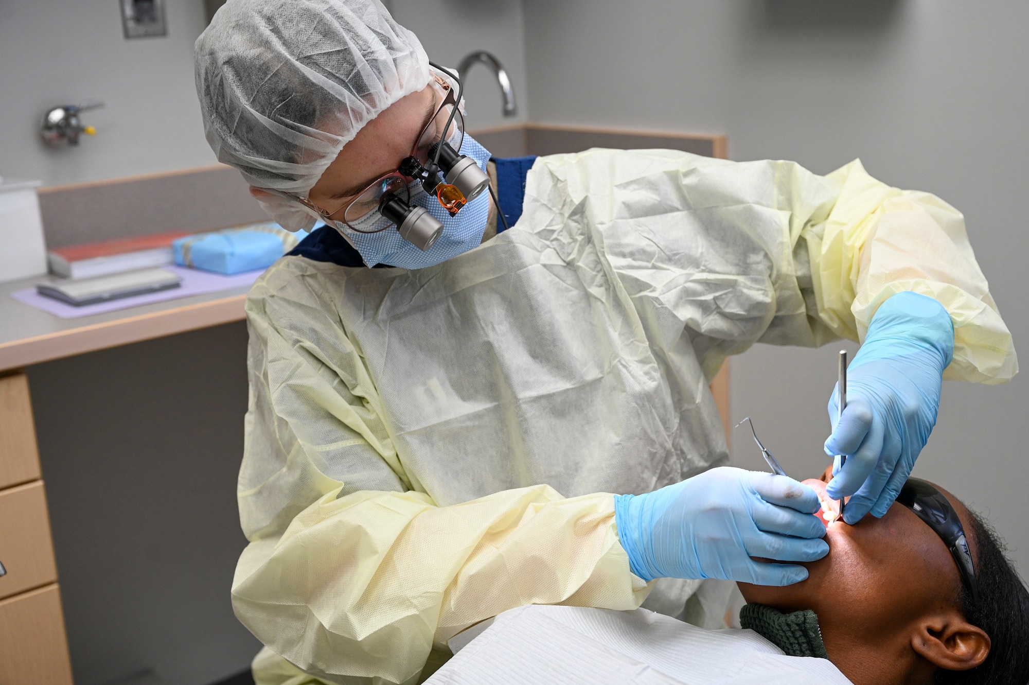 U.S. Air Force Capt. Despina Gensch, a dentist with the Bolling Medical Squadron, gives an oral exam at Joint Base Anacostia-Bolling, Washington, D.C., Jan. 9, 2026. Gensch administered the exam to ensure pre-deployment medical readiness for Airmen, continuing the Bolling Medical Squadron standard of world-class medical and dental care. (U.S. Air Force photo by Airman 1st Class Shanel Toussaint)