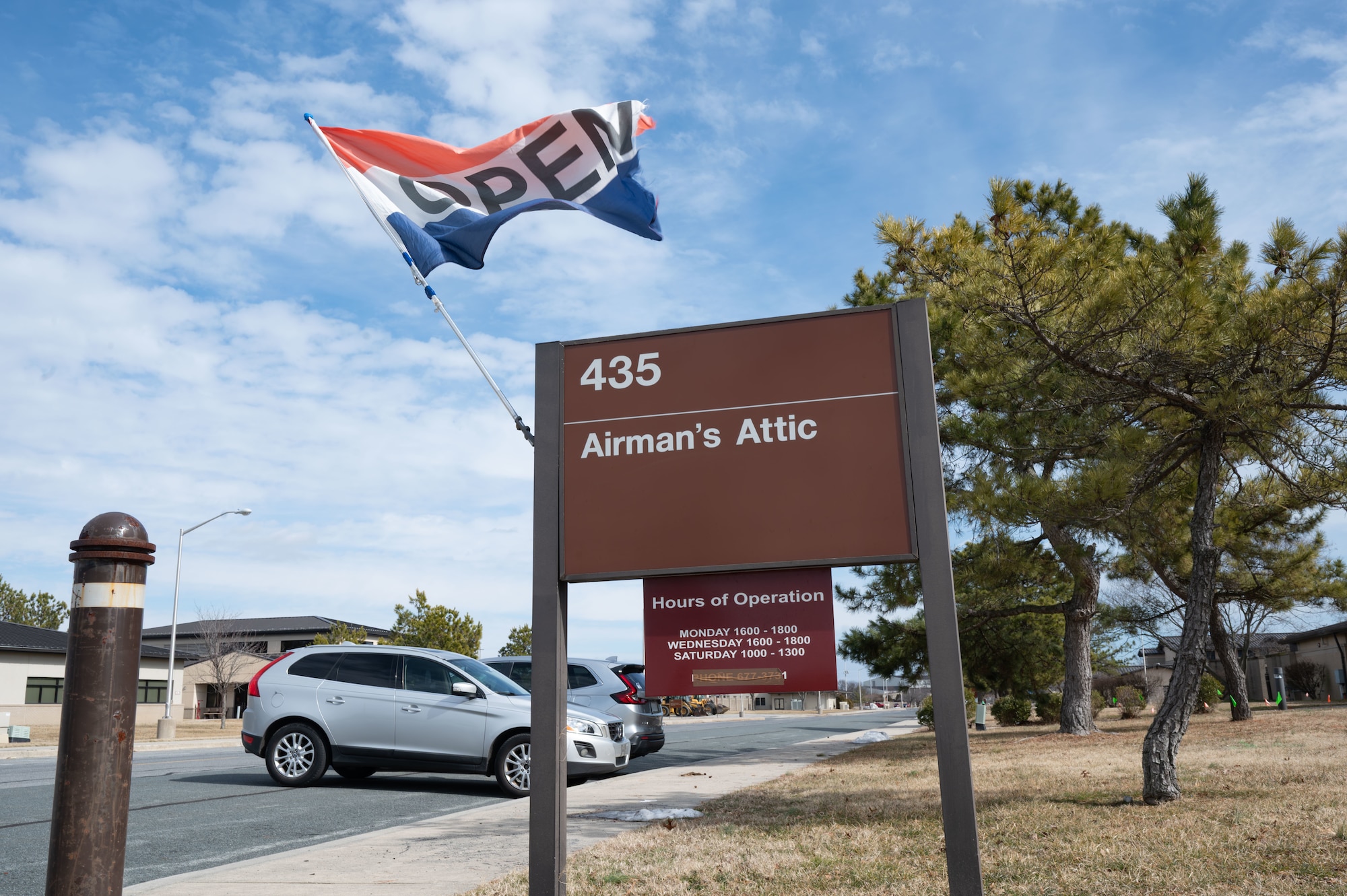 An “open” flag waves above the sign for the Airmen’s Attic on Dover Air Force Base, Delaware, Feb. 21, 2026. The Airmen’s Attic is open Monday and Wednesday afternoons, as well as on late Saturday mornings. (U.S. Air Force photo by Airman 1st Class Liberty Kuhn)
