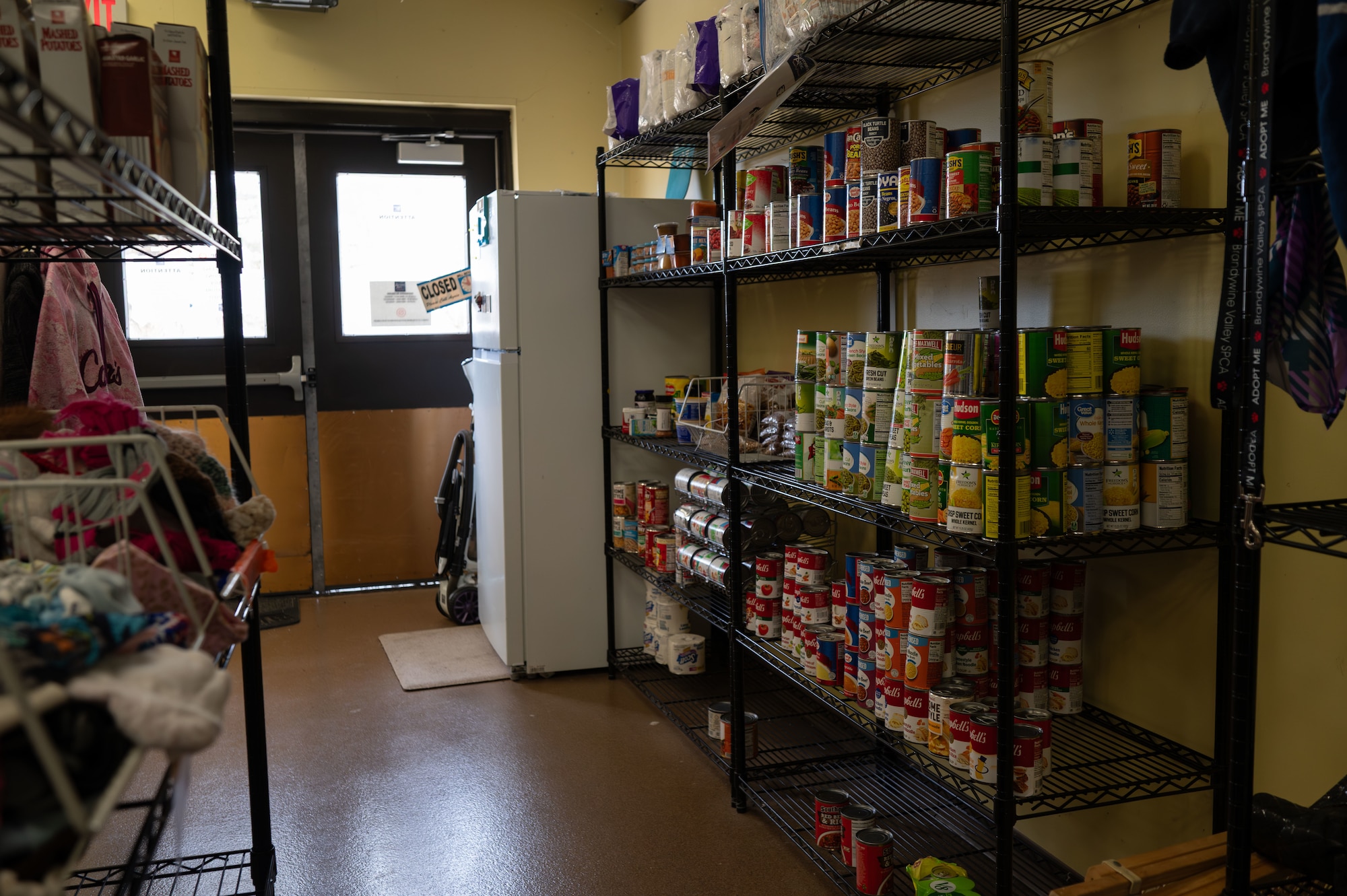 Canned goods sit on shelves at the Airmen’s Attic on Dover Air Force Base, Delaware, March 2, 2026. Donations such as canned food items are accepted as they help Airmen to keep their food supply stocked, or in case of an emergency. (U.S. Air Force photo by Airman 1st Class Liberty Kuhn)