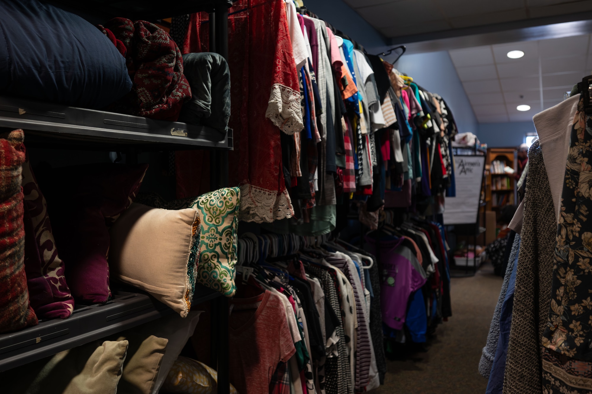 Clothing and pillows fill the racks and shelves of the Airmen’s Attic on Dover Air Force Base, Delaware, March 2, 2026. Team Dover members are encouraged to donate clothing, household items, books, movies and canned goods that are no longer used. (U.S. Air Force photo by Airman 1st Class Liberty Kuhn)
