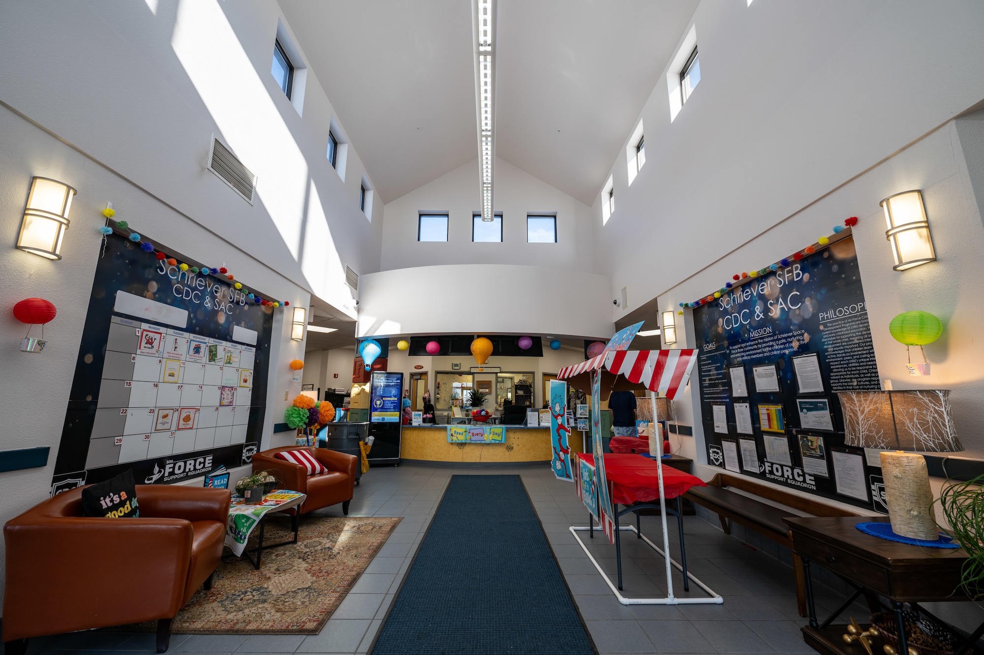 The entrance area of the Child Development Center is shown with a welcome desk, sitting area, and bulletin boards.