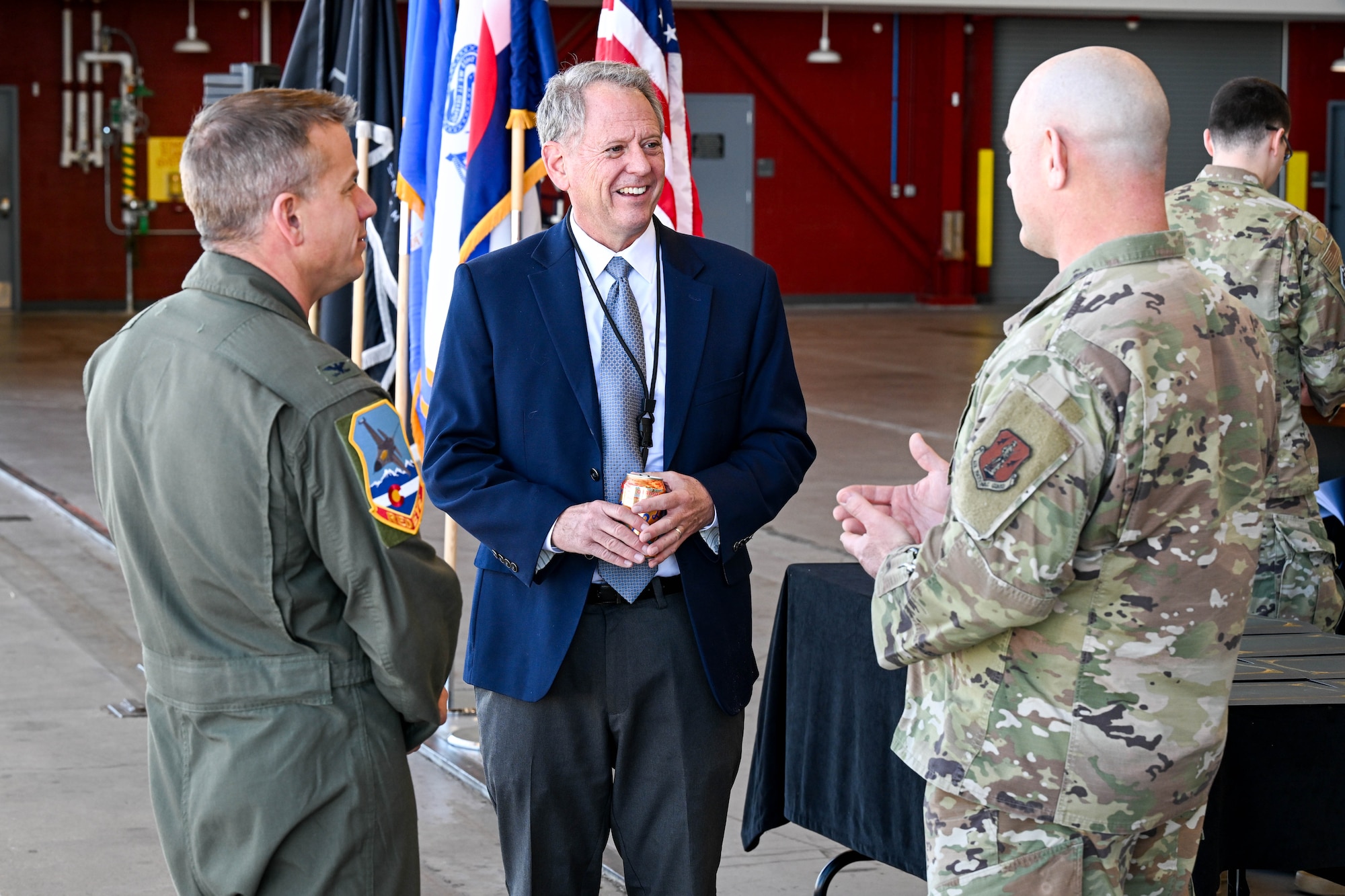 three people talking in hanger