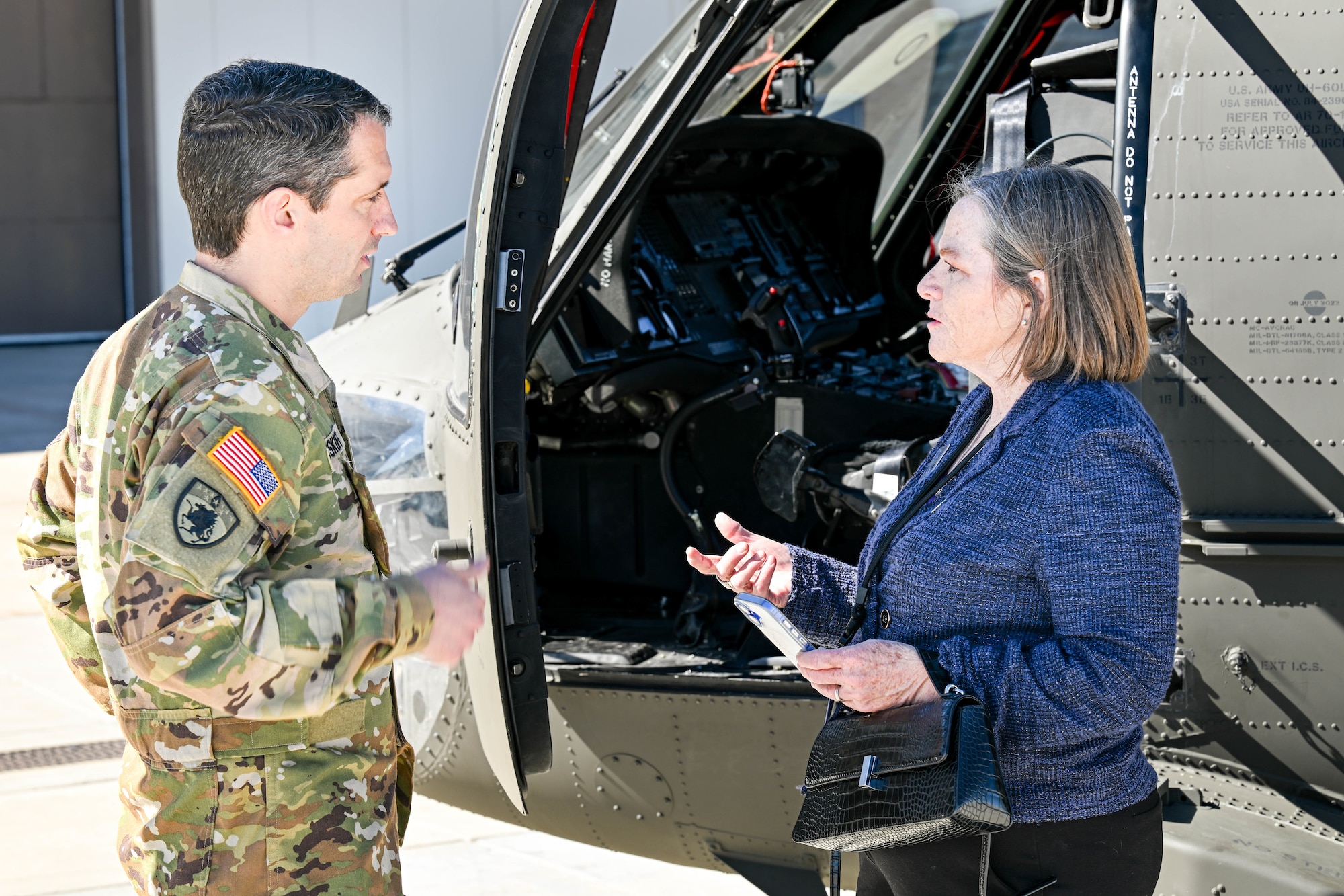 two people speaking in front of helicopter