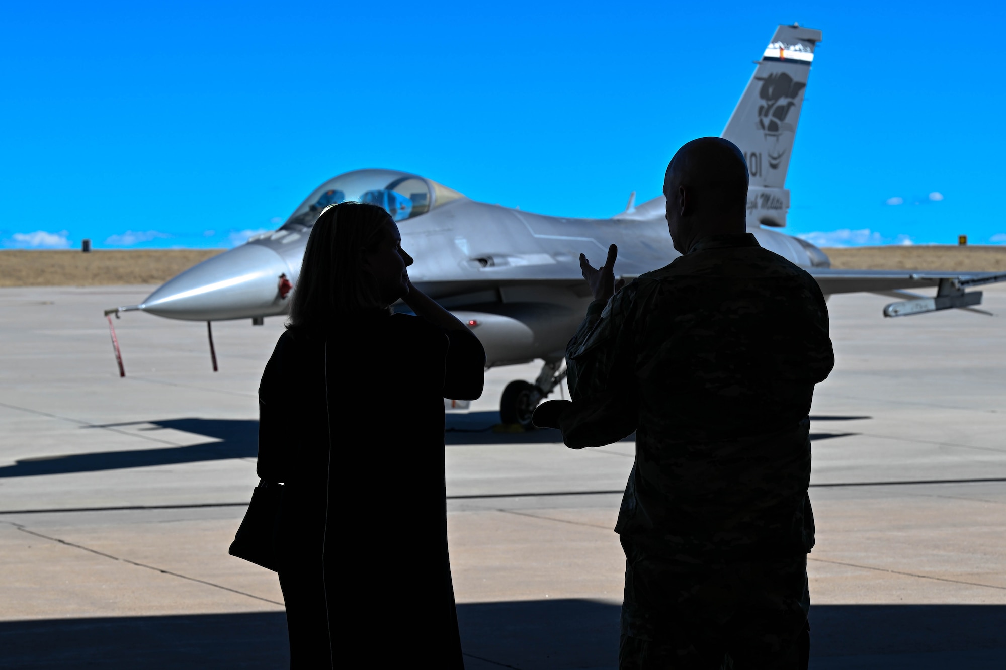 two people talk in front of a jet