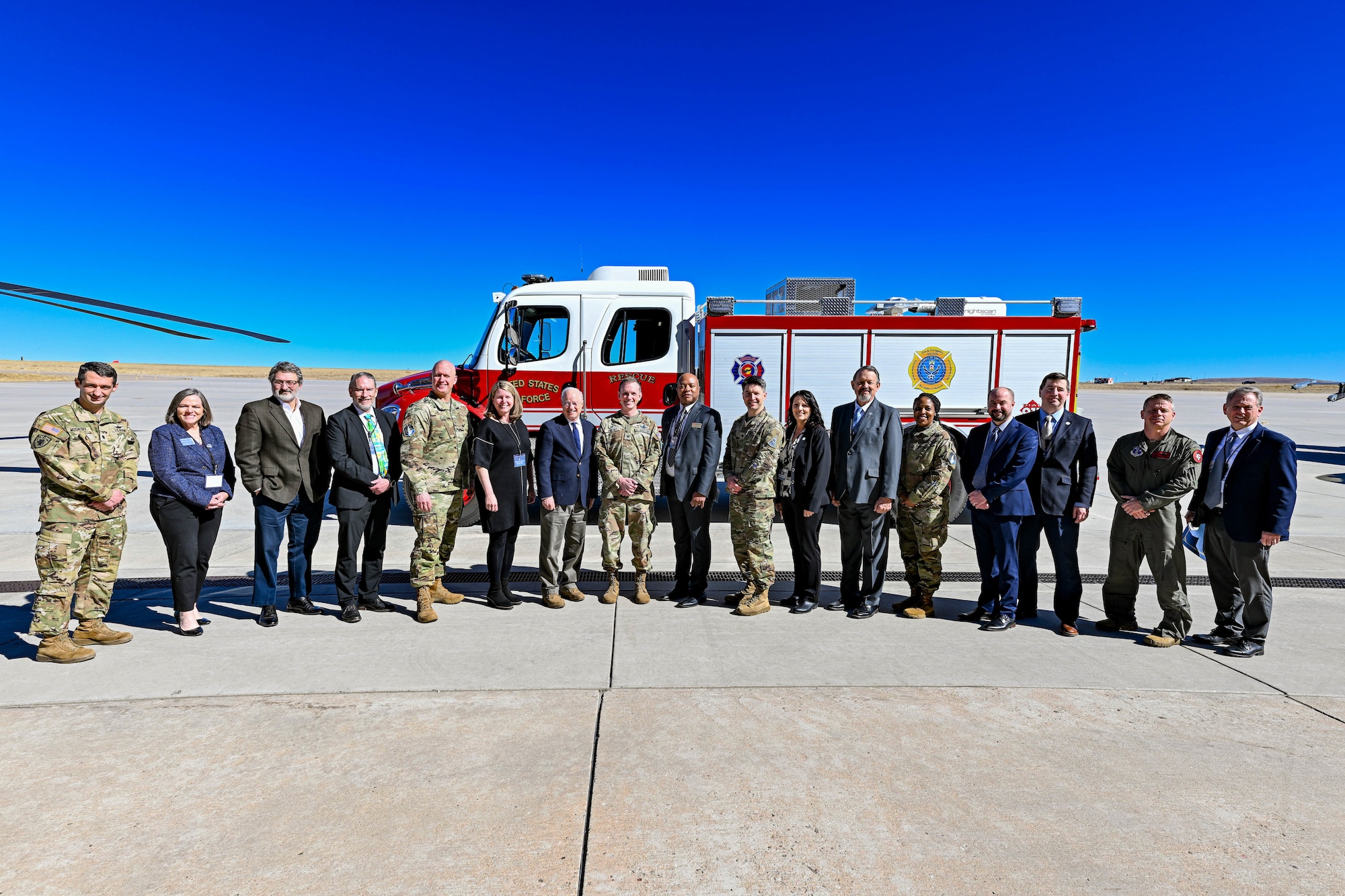 group of people stand in front of a fire truck