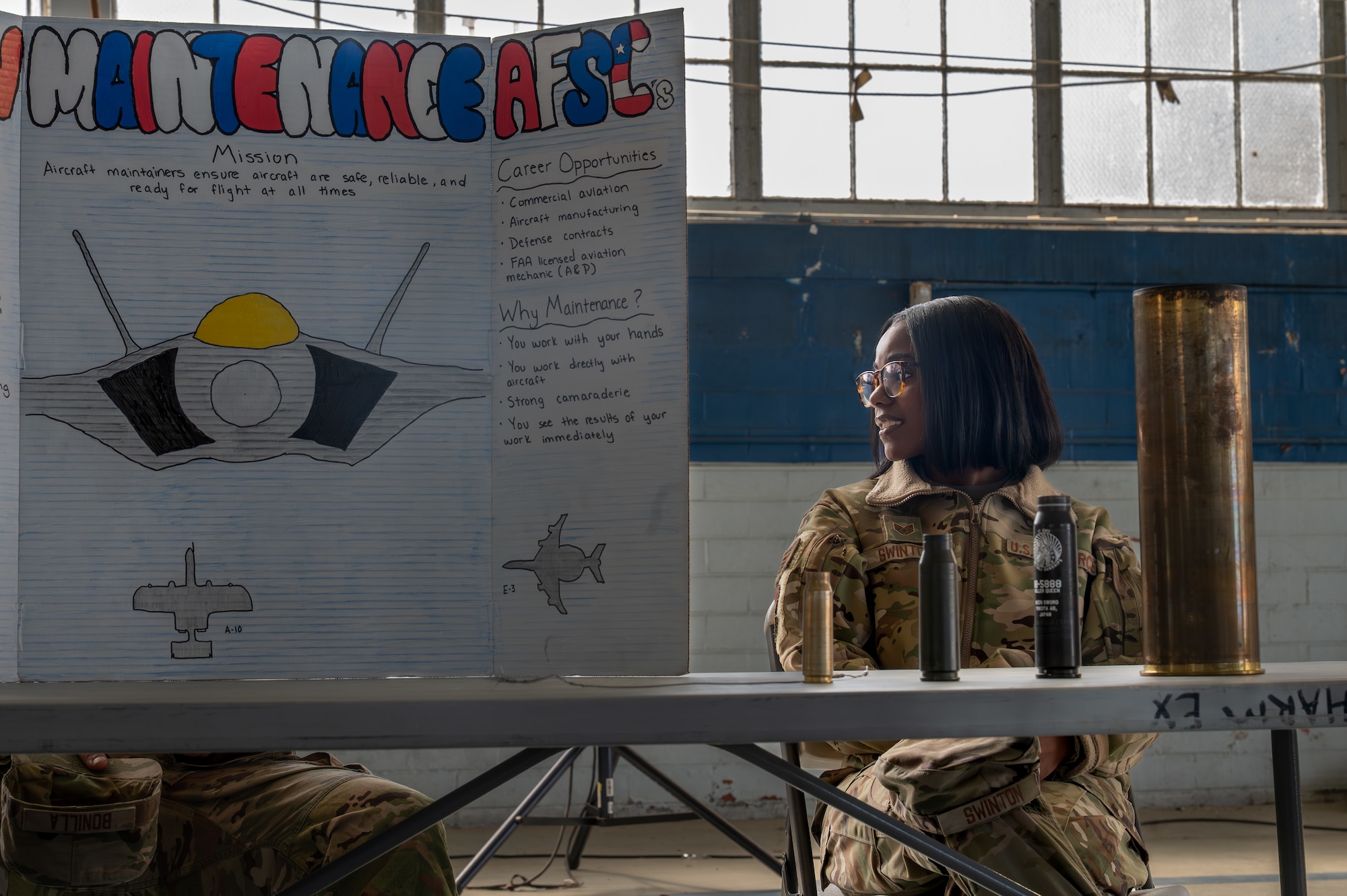 A Dannelly Field Airmen sits and speaks to a peer in the honor guard hangar.