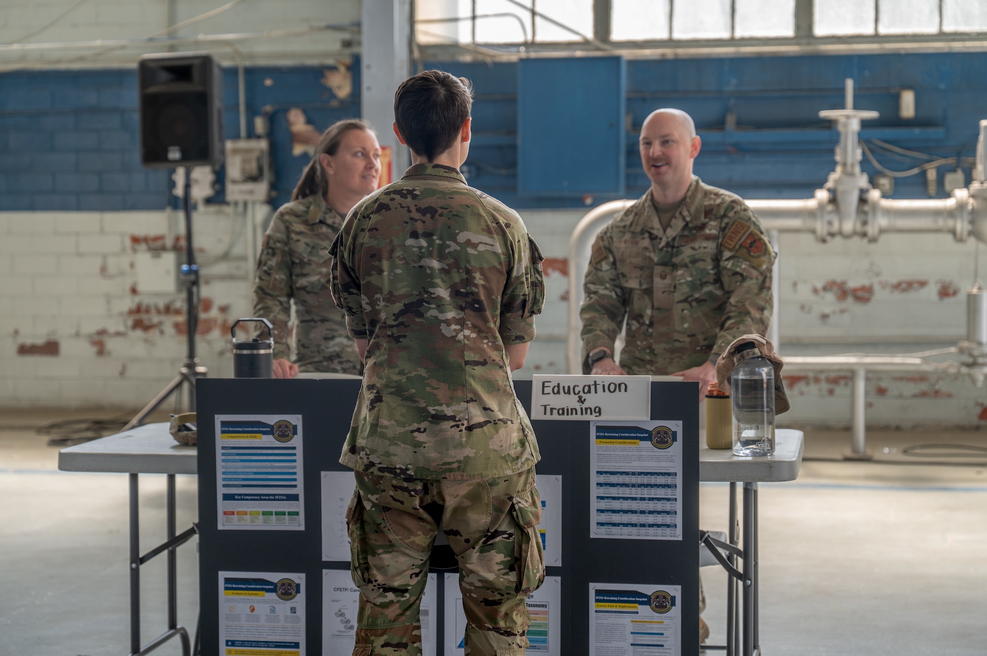 Maxwell Air Force Base Airmen talk inside the honor guard hangar.