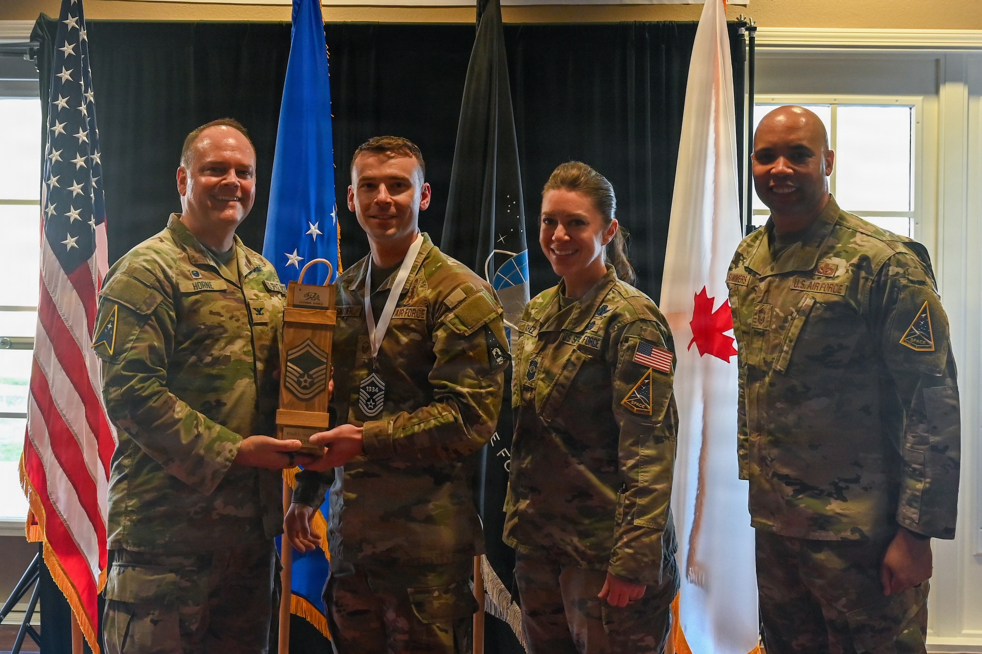 U.S. Air Force Master Sgt. Elijah Snyder, operations superintendent for the National Reconnaissance Office, a Senior Master Sgt. select, receives a promotion trophy