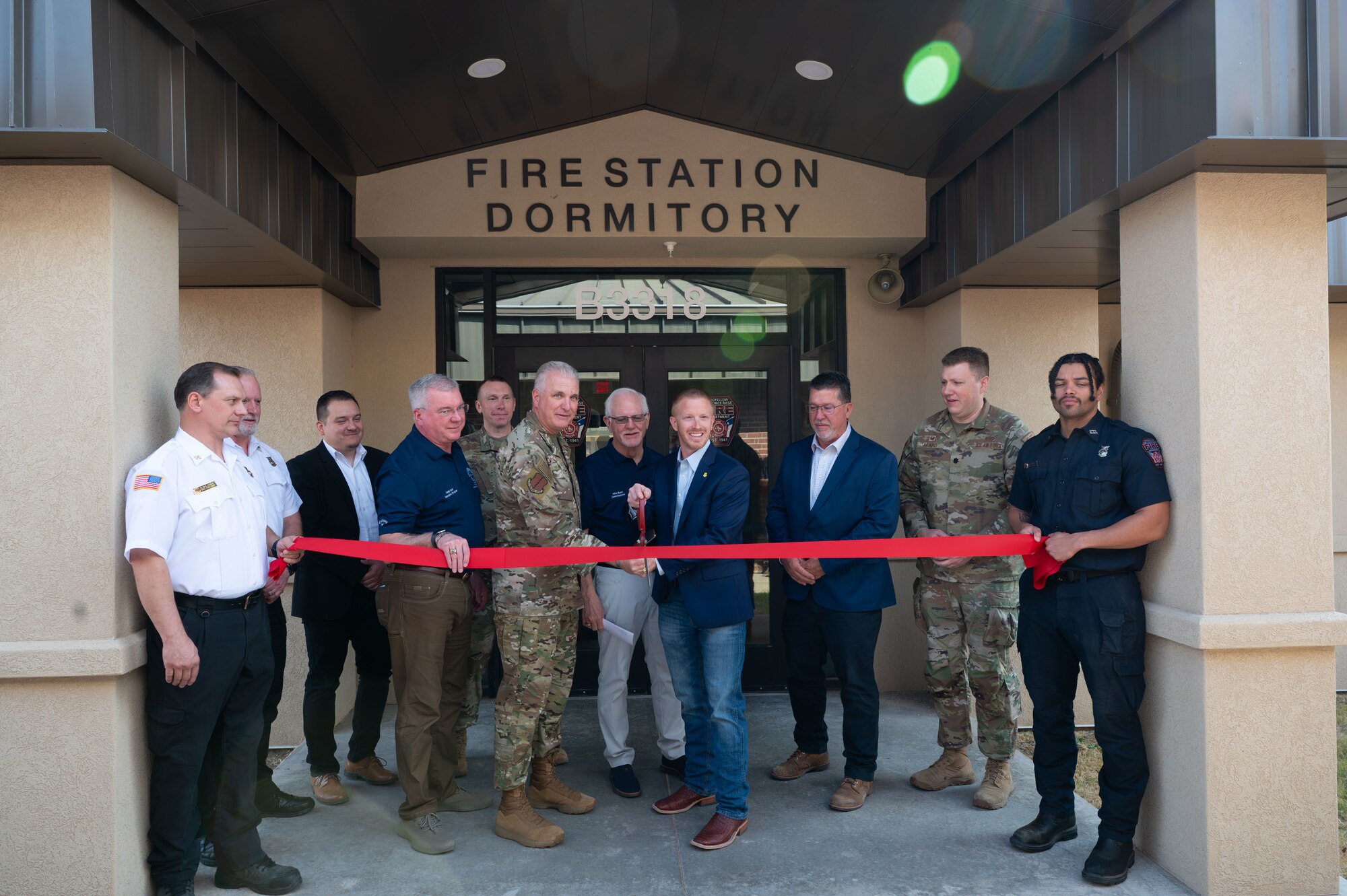 Base leadership and community members cut the red ribbon at the Goodfellow Fire Department dorms ribbon-cutting ceremony