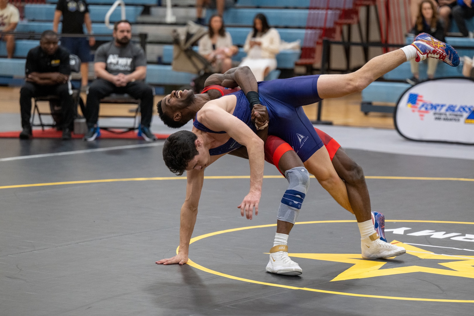 U.S. Army Staff Sgt. Xavier Johnson, assigned to Fort Carson, Colorado, and U.S. Air Force Airman 1st Class Taylor Vasquez, assigned to Nellis Air Force Base, Nevada, wrestle during the Armed Forces Sports Men’s and Women’s Wrestling Championships at the Mitchell W. Stout Physical Fitness Center on Fort Bliss, Texas, March 14, 2026. Service members compete in Greco-Roman and freestyle wrestling for championship honors while representing their respective services.