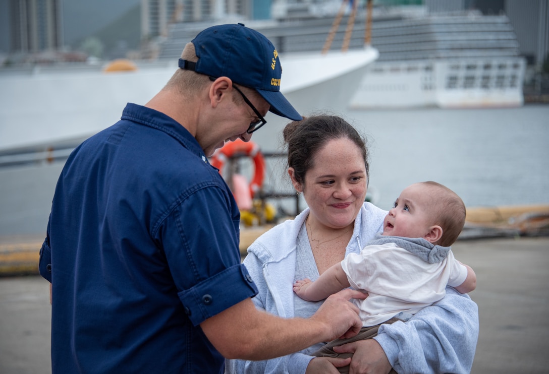 U.S. Coast Guard Petty Officer 1st Class Tyler Burkert, a crew member assigned to the fast response cutter USCGC William Hart (WPC 1134), greets his wife, Brittany, and son, Hayes, on Coast Guard Base Honolulu March 15, 2026. For 48 days, the William Hart crew patrolled Oceania, exercised partnerships with Samoa and Cook Islands through bilateral maritime law enforcement agreements, and patrolled the U.S. maritime border and its approaches in American Samoa. (U.S. Coast Guard photo by Chief Petty Officer Corinne Zilnicki)