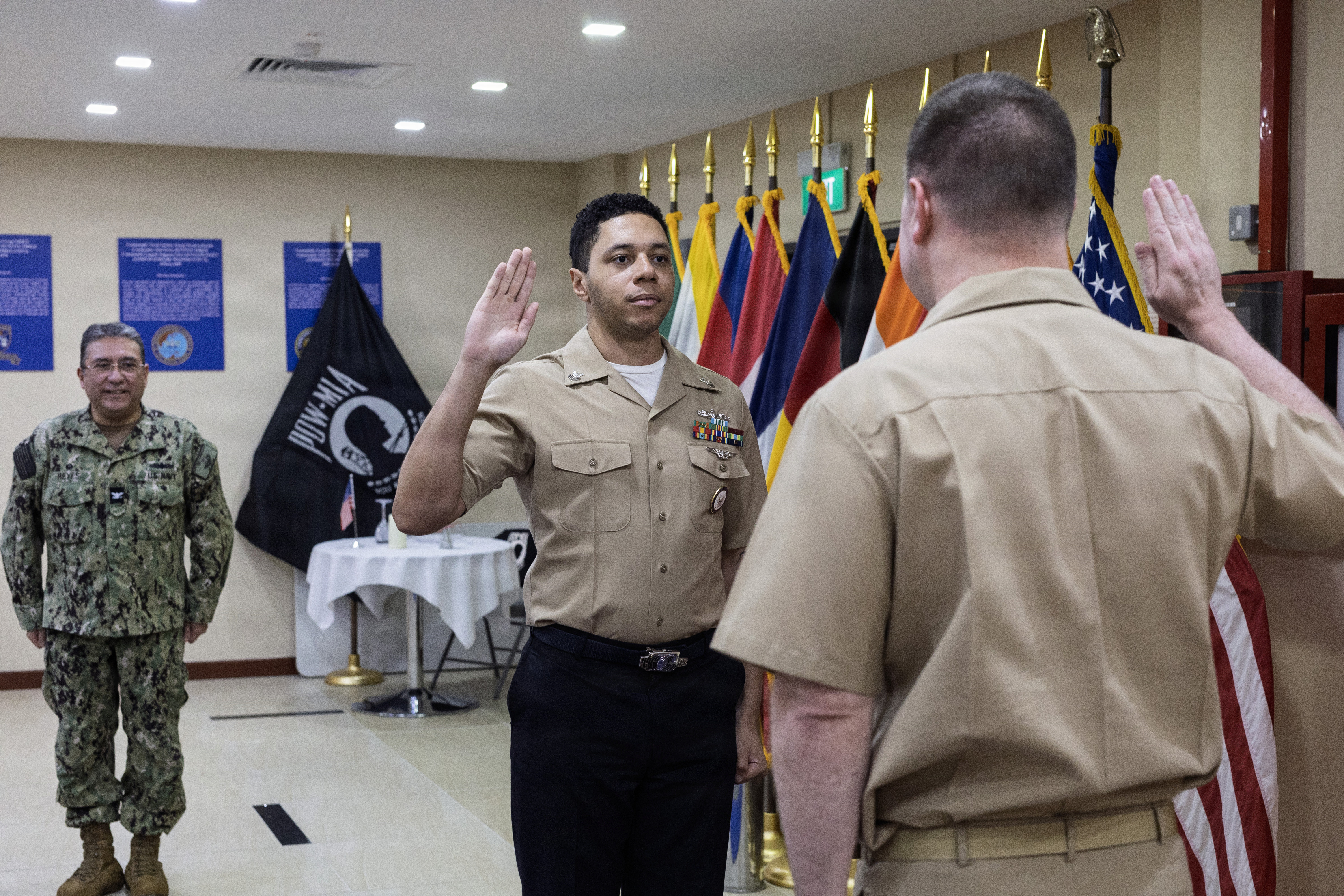 Yeoman 1st Class Robert J. Carter, center, administrative officer assistant, Military Sealift Command (MSC) Far East, pledges the oath of enlistment during his re-enlistment ceremony at MSC Far East headquarters, Singapore Naval Installation, Singapore, Feb. 26, 2026.