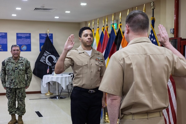 Yeoman 1st Class Robert J. Carter, center, administrative officer assistant, Military Sealift Command (MSC) Far East, pledges the oath of enlistment during his re-enlistment ceremony at MSC Far East headquarters, Singapore Naval Installation, Singapore, Feb. 26, 2026.