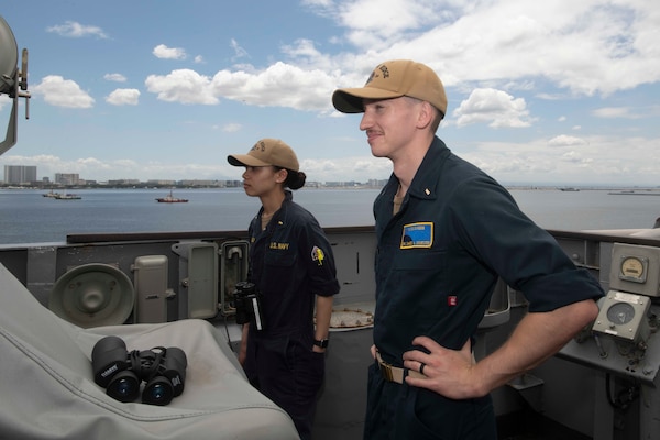 Ensign Ayana Bullock, left, and Ensign Chance Sylvester look out from the bridge wing aboard U.S. 7th Fleet flagship USS Blue Ridge (LCC 19) as the ship prepares to enter port in Manila, Philippines, March 16, 2026.