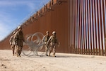 U.S. Marines with Combat Logistics Battalion 15 (CLB 15), Combat Logistics Regiment 17, 1st Marine Logistics Group, assigned to Joint Task Force-Southern Border (JTF-SB), carry concertina wire into position for installation in Yuma, Arizona, Nov. 17, 2025. CLB 15’s barrier reinforcement operations aim to enhance physical security measures on the existing southern border barrier. JTF-SB executes full-scale, agile, and all-domain operations in support of U.S. Customs and Border Protection to protect the territorial integrity of the United States and achieve 100% operational control of the southern border.   (Photo Credit: Photo by U.S. Marine Corps Sgt. Mary Torres)