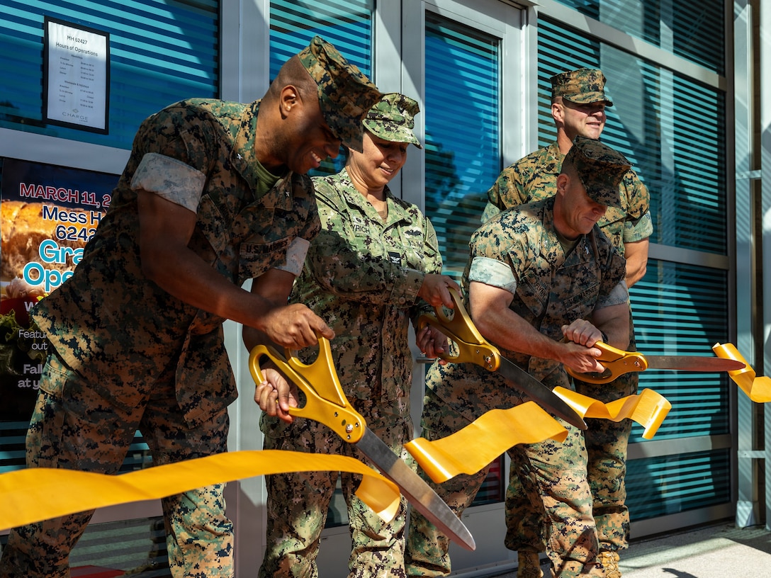 From left to right, U.S. Marine Corps Brig. Gen. Brown, commanding general of Marine Corps Installations West, Marine Corps Base Camp Pendleton; Navy Capt Eyrich, commanding officer of Naval Facilities Engineering Systems Command Southwest; and Marine Corps Col. Flynn III, commanding officer of Headquarters Company, 5th Marine Regiment, 1st Marine Division, cut a ribbon during a ribbon-cutting ceremony for the new 62 Area dining facility at MCB Camp Pendleton, Calif., March 11, 2026. The ceremony marked the official opening of the facility, providing Marines and Sailors access to improved food services and an enhanced quality of life. (U.S. Marine Corps photo by Cpl. Martinez)