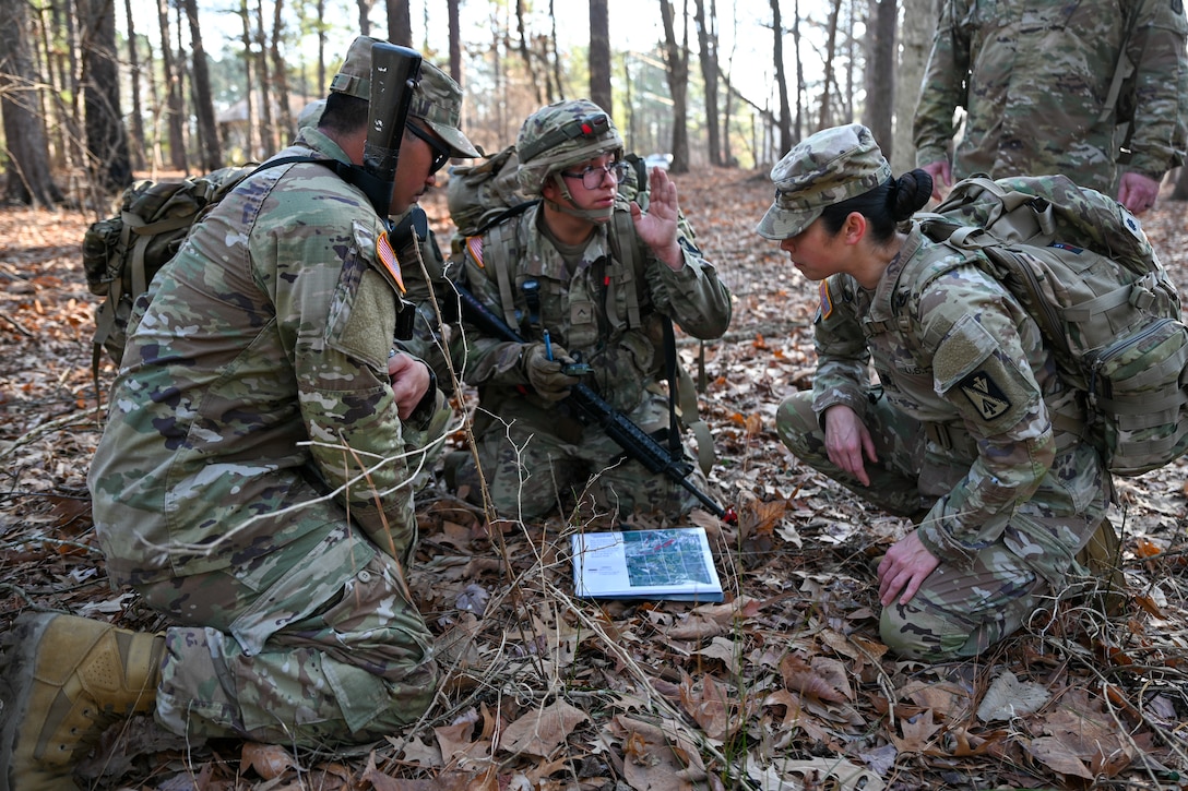 Soldiers kneel around a map. (U.S. Air Force photo by Airman 1st Class Donnell Ramsey)