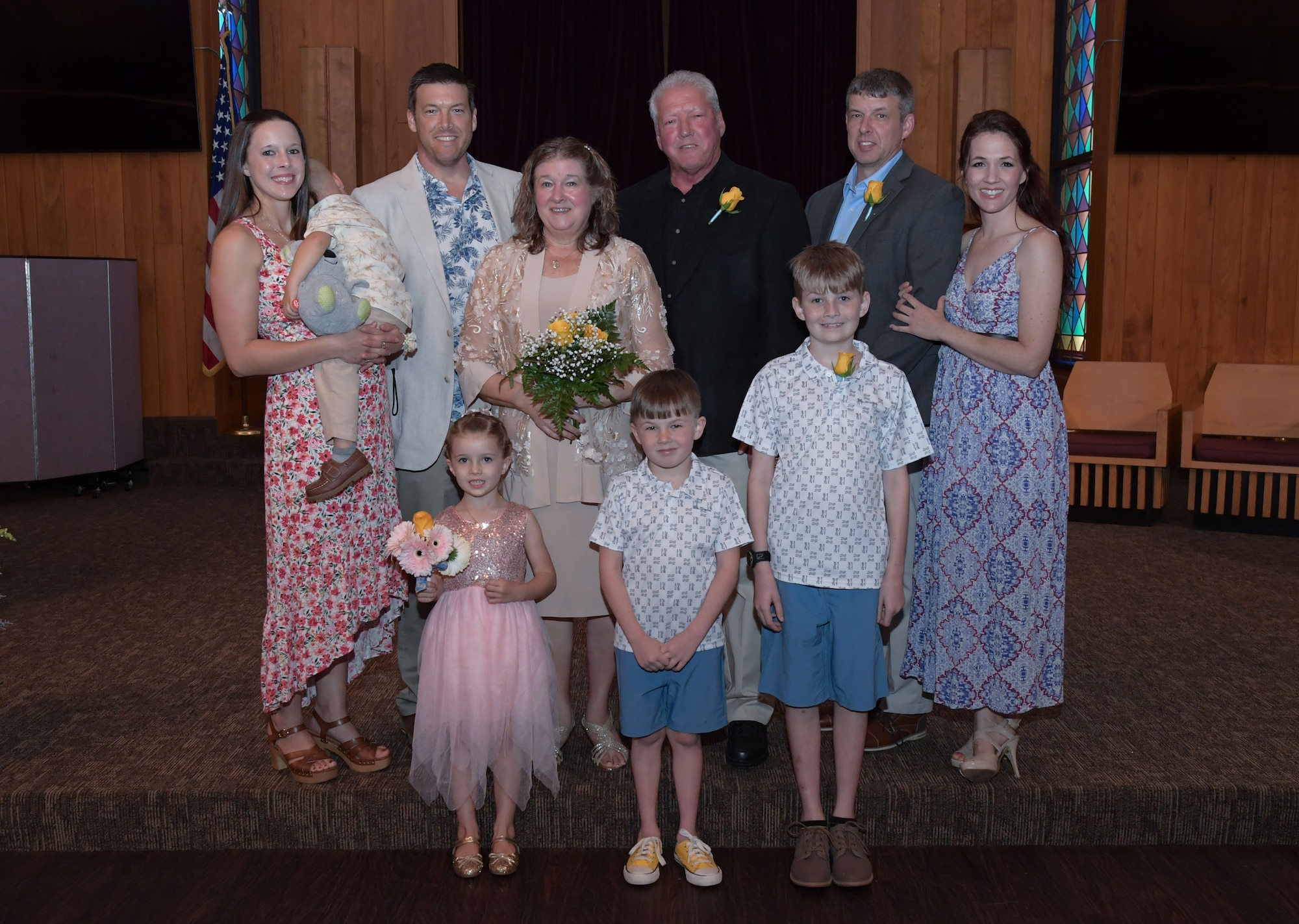 A group of family members gather for a photo in a chapel.