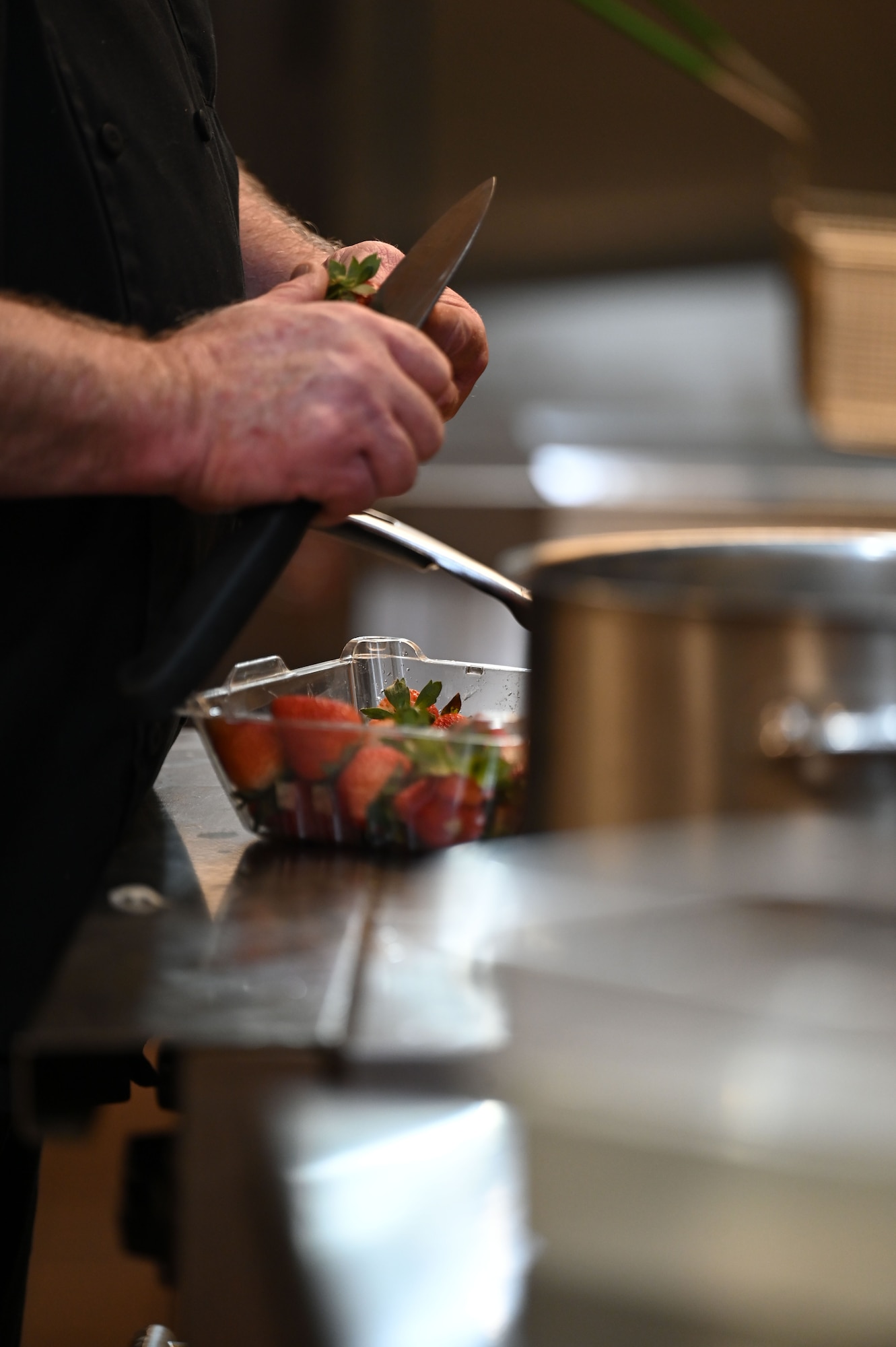 Mr. Cordell “Bo” Bomar, 5th Force Support Squadron Executive Chef, prepares strawberries during an internal cooking competition at the dining facility at Minot Air Force Base, North Dakota, Feb. 12, 2026. While directing both teams throughout the cook-off, Mr. Bomar also created his own dish that was offered in the dining facility for Airmen to sample. (U.S. Air Force photo by Airman Joseline Chacon Monterroso)