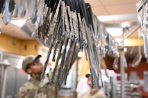 Serving tongs hang for use during an internal cooking competition at Minot Air Force Base, North Dakota, Feb. 12, 2026. Airmen assigned to the facility competed against one another to showcase their culinary skills and creativity while strengthening teamwork in the kitchen. (U.S. Air Force photo by Airman Joseline Chacon Monterroso)