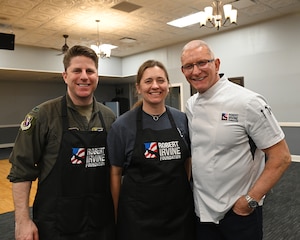 From left, U.S. Air Force Col. James Blech, 14th Flying Training Wing commander; U.S. Air Force Reserve Lt. Col. Stephanie Blech, Admission Liaison Officer; and Chef Robert Irvine, Robert Irvine Foundation founder, participate in a "Breaking Bread with Heroes" event at the Event Center on Columbus Air Force Base, Mississippi, Feb. 27, 2026.