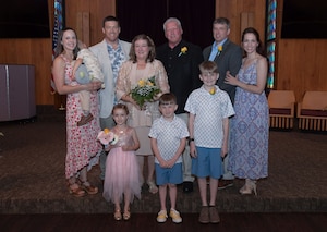 A group of family members gather for a photo in a chapel.