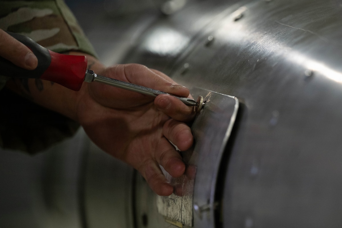 airmen inspect a munition during a load demo