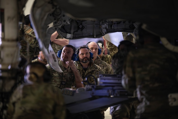 airmen and other service members watch a load demo