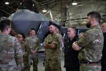 airmen and other service members listen to a briefing