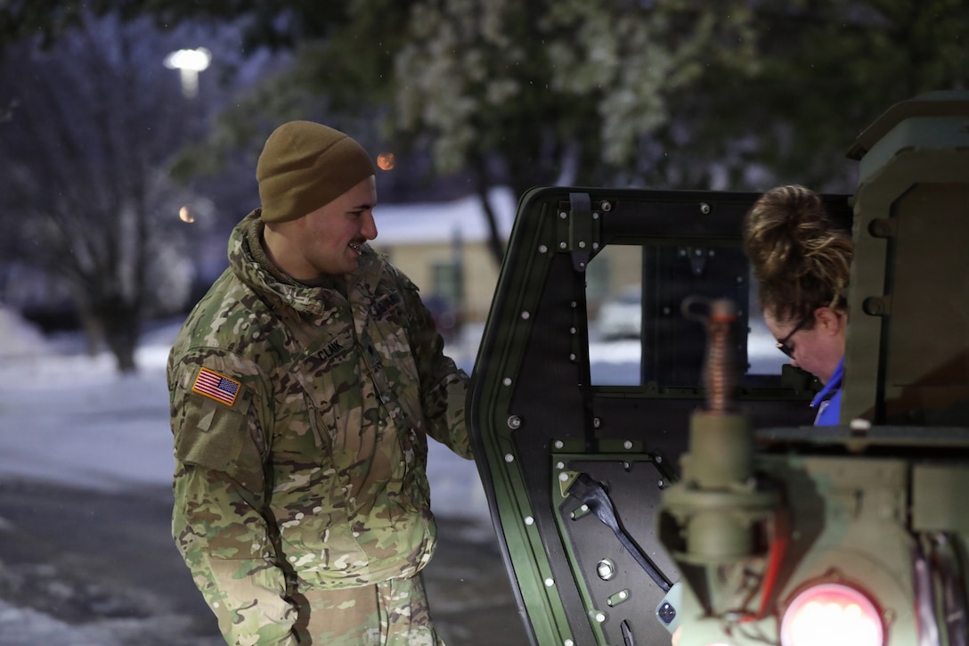 A Soldier with the 63rd Theater Aviation Brigade assists a citizen out of a HUMVEE after helping her get to work in Frankfort Kentucky, during Winter Storm Fern Jan. 26, 2026.
