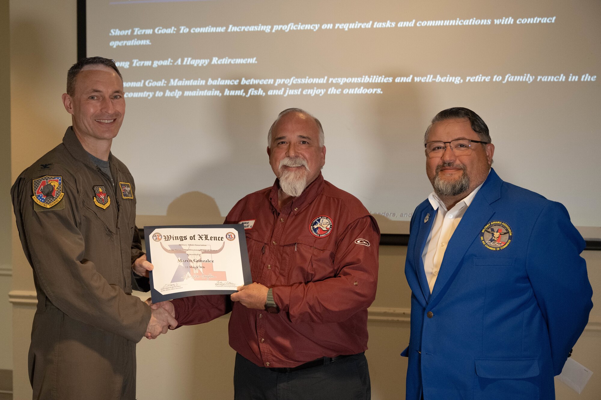 U.S. Air Force Col. Tyler Ellison, 47th Flying Training Wing commander, and Eddie Amezuca, Del Rio Military Affairs Association president, present the Wings of XLence certificate to Marco Gonzalez, 47th Maintenance Directorate contract officer’s representative, at Laughlin Air Force Base, Texas, March 13, 2026. Gonzalez was awarded the certificate for being the 47 MXD’s top quarterly performer during the Wings of XLence luncheon. (U.S. Air Force photo by Airman 1st Class Darryl Keith)
