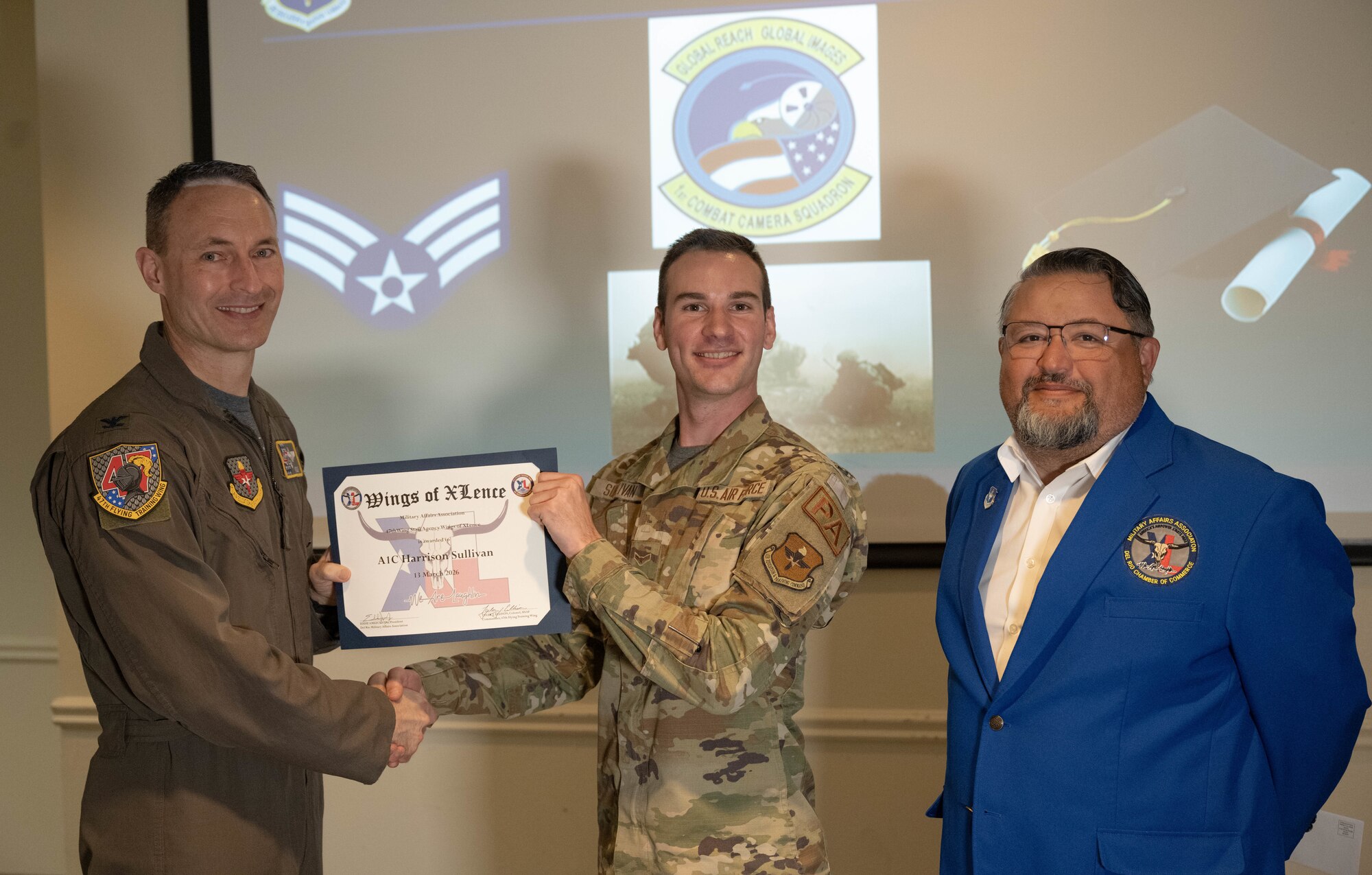 U.S. Air Force Col. Tyler Ellison, 47th Flying Training Wing commander, and Eddie Amezuca, Del Rio Military Affairs Association president, present the Wings of XLence certificate to Airman 1st Class Harrison Sullivan, 47th Wing Staff Agency public affairs journeyman, at Laughlin Air Force Base, Texas, March 13, 2026. The Wings of XLence is awarded to the top quarterly performs from each group throughout the 47 FTW. (U.S. Air Force photo by Airman 1st Class Darryl Keith)