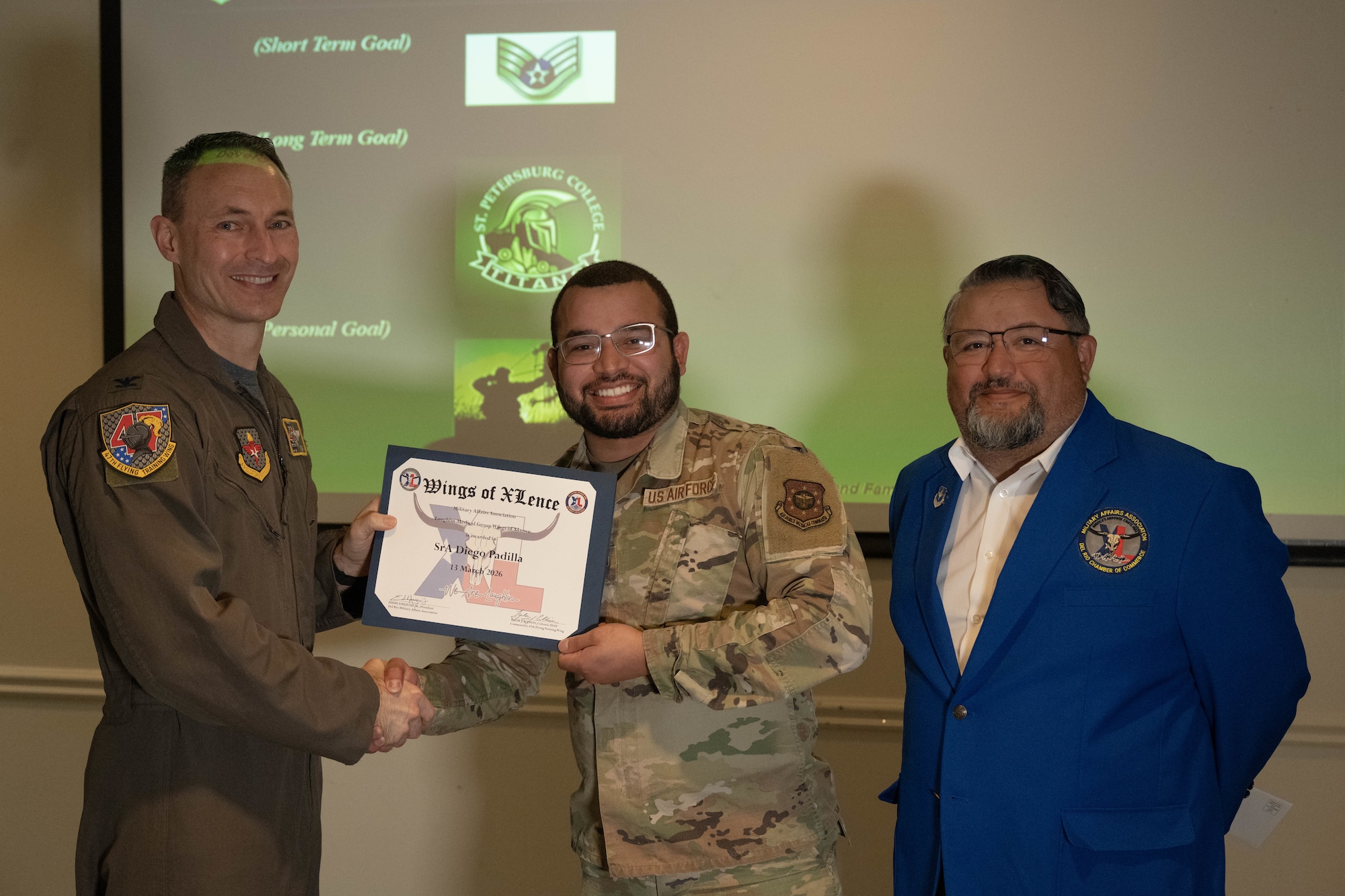 U.S. Air Force Col. Tyler Ellison, 47th Flying Training Wing commander, and Eddie Amezuca, Del Rio Military Affairs Association president, present the Wings of XLence certificate to Senior Airman Diego Padilla, Laughlin Operational Medical Readiness Squadron dental assistant, at Laughlin Air Force Base, Texas, March 13, 2026. Padilla was recognized as the top performer from the Laughlin Medical Group during the Wings of XLence luncheon. (U.S. Air Force photo by Airman 1st Class Darryl Keith)