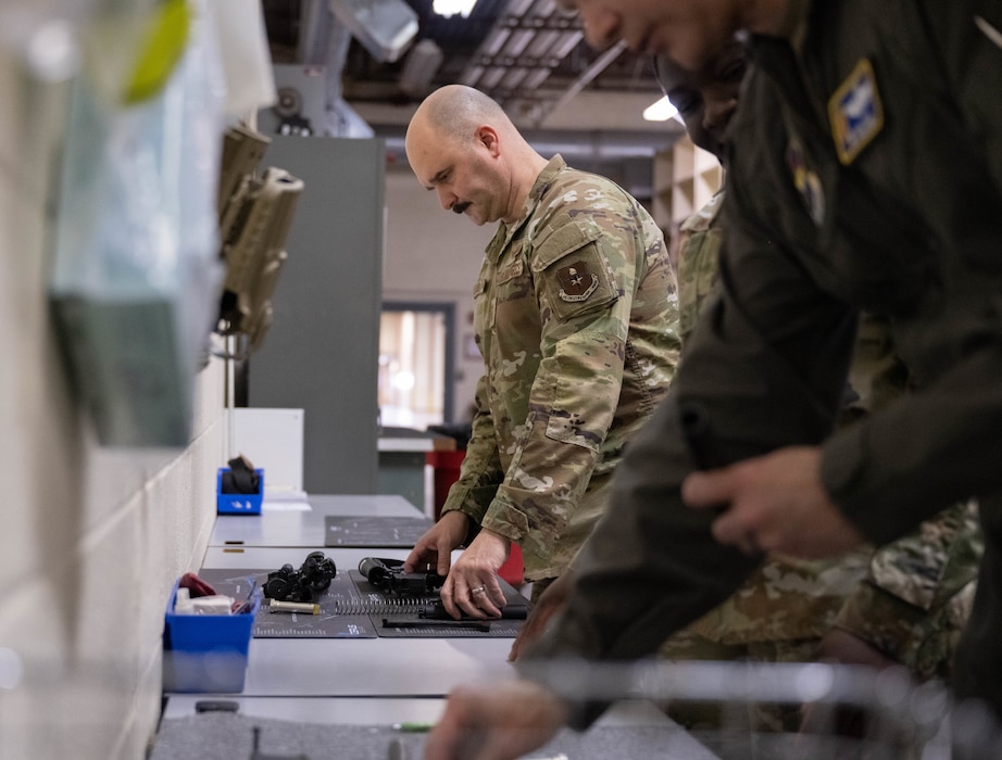 U.S. Air Force Chief Master Sgt. Jonny Adams, 97th Air Mobility Wing (AMW) command chief, disassembles and reassembles a weapon at Altus Air Force Base, Oklahoma, Feb. 25, 2026. The 97th AMW command team completed a hands-on immersion tour with the 97th Logistics Readiness Squadron (LRS), during which they competed to see who could complete the assembly and function check the fastest. (U.S. Air Force photo by Airman 1st Class Emma Wright)