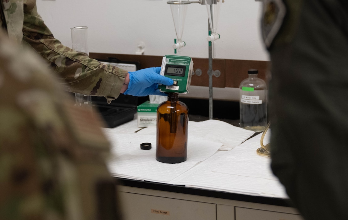 U.S. Air Force Staff Sgt. Christopher Fairchild, 97th Logistics Readiness Squadron (LRS) fuels laboratory non-commissioned officer in charge, holds a Digital Conductivity Meter at Altus Air Force Base, Oklahoma, Feb. 25, 2026. The 97th Air Mobility Wing command team collaborated with the 97th LRS during a hands-on immersion tour, during which Fairchild explained the process of receiving fuel and taking samples from those receipts to verify quality. (U.S. Air Force photo by Airman 1st Class Emma Wright)