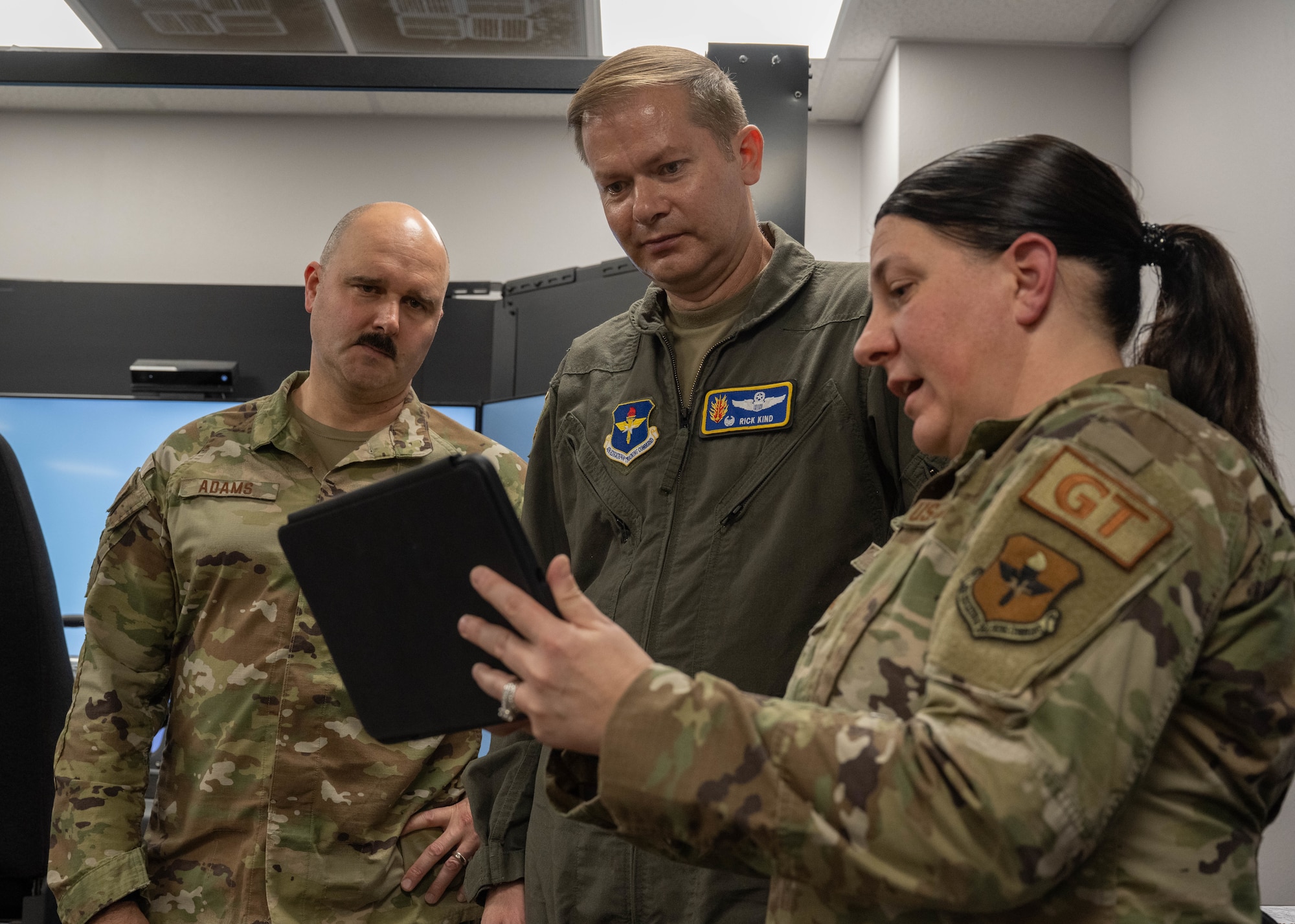 U.S. Air Force Staff Sgt. Heather Grigg, 97th Logistics Readiness Squadron (LRS) ground transportation support non-commissioned officer in charge, right, displays the AI virtual vehicle inspection courses to Col. Richard Kind, 97th Air Mobility Wing (AMW) commander, center, and Chief Master Sgt. Jonny Adams, 97th AMW command chief, left, at Altus Air Force Base, Oklahoma, Feb. 25, 2026. Grigg demonstrated the 97th LRS innovative approach to enhancing safety and mission-readiness through the Driving Simulator and AI vehicle inspection platform during a hands-on immersion tour with the 97th AMW command team. (U.S. Air Force photo by Airman 1st Class Emma Wright)